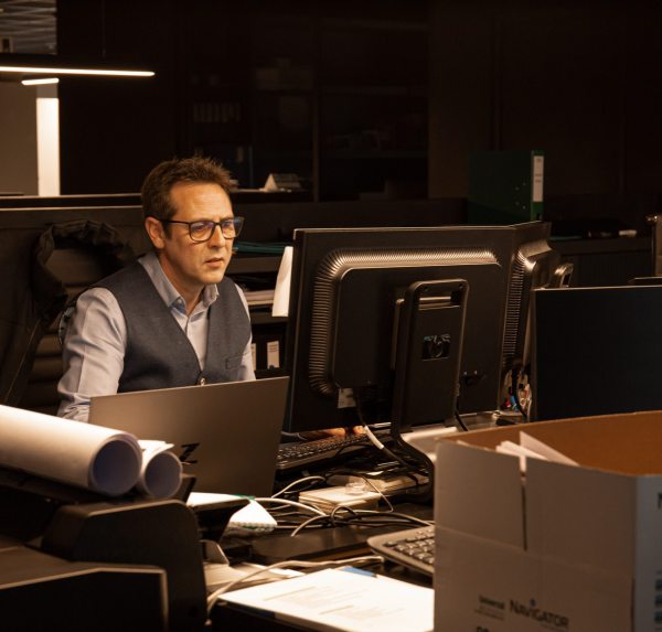 Een man achter zijn bureau. Werkend achter de computer.